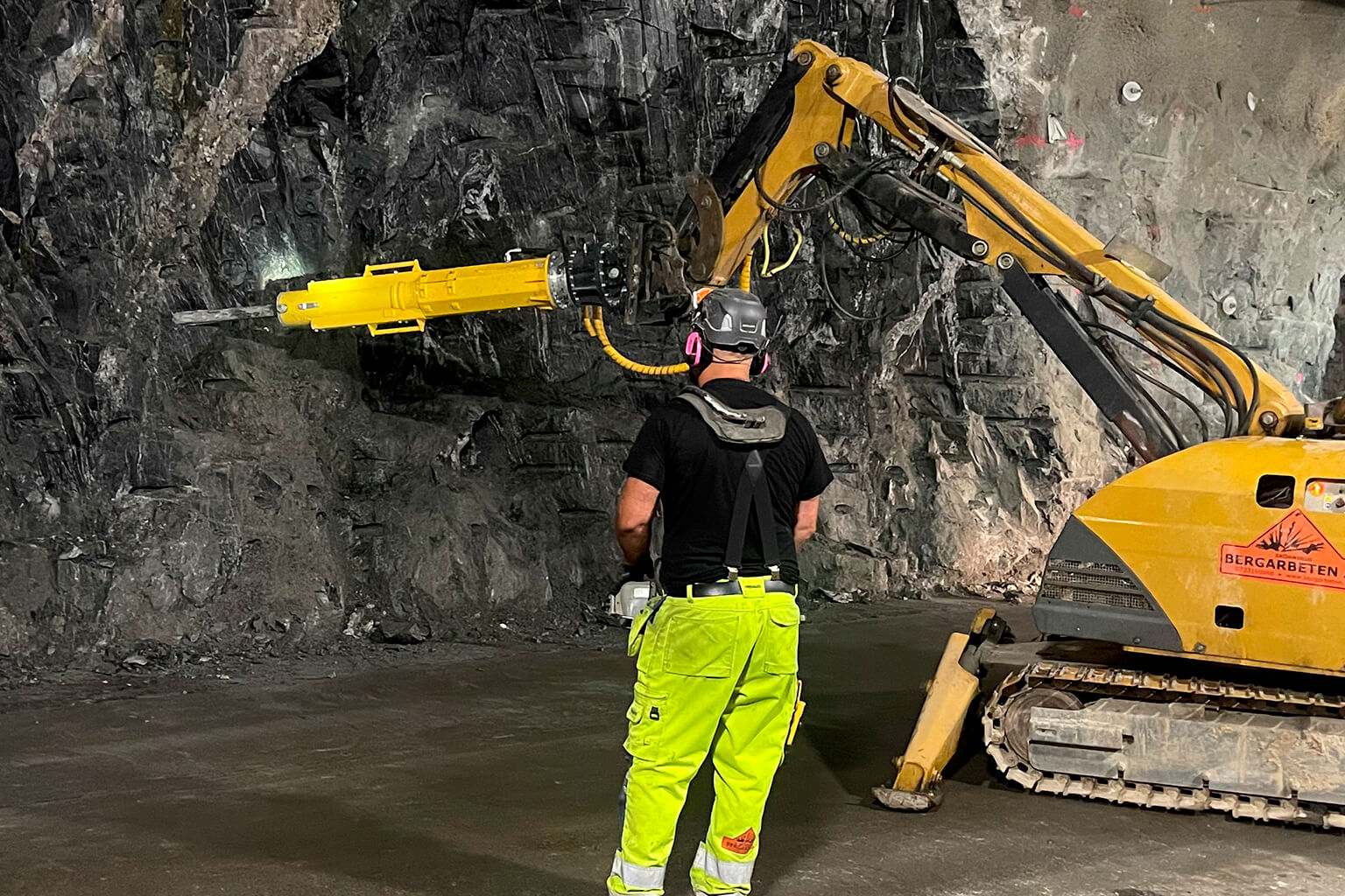 Darda C20 carrier-mounted rock splitter working a quarry face